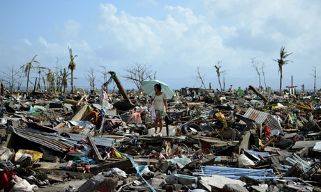 Surivor in Tacloban walks among the debris after Typhoon Haiyan